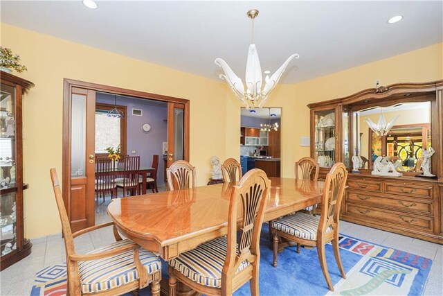 tiled dining area featuring a chandelier