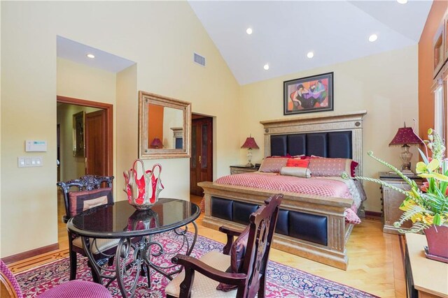 bedroom with light hardwood / wood-style flooring and high vaulted ceiling