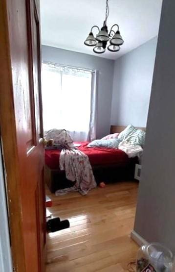 2319 W 12th St, Brooklyn, NY 11223 - bedroom with a chandelier and wood finished floors