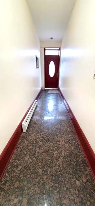 2319 W 12th St, Brooklyn, NY 11223 - doorway to outside featuring baseboards and a baseboard heating unit