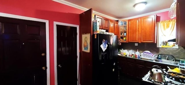 2319 W 12th St, Brooklyn, NY 11223 - kitchen featuring freestanding refrigerator, backsplash, glass insert cabinets, brown cabinetry, and a sink
