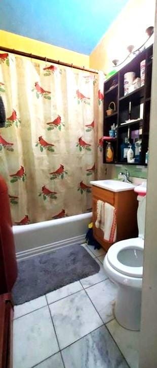 full bathroom with tile patterned floors, toilet, sink, and shower / bath combo with shower curtain