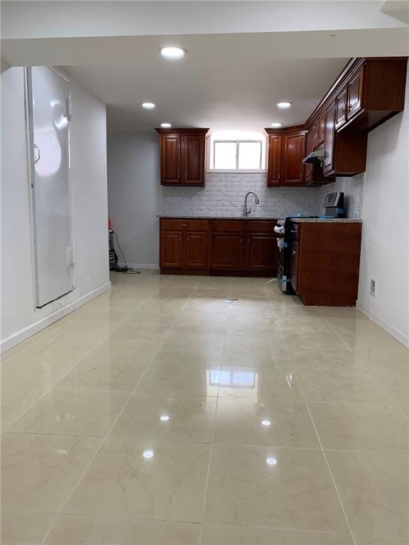 kitchen with light tile patterned flooring, sink, range, and backsplash