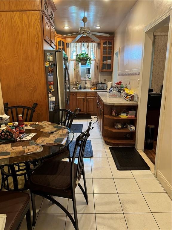 kitchen featuring light tile patterned floors, stainless steel fridge, ceiling fan, and decorative backsplash