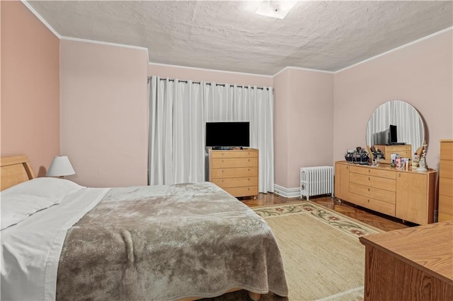 bedroom with hardwood / wood-style floors, crown molding, radiator heating unit, and a textured ceiling