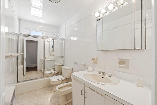 full bathroom with toilet, combined bath / shower with glass door, tile walls, a bidet, and vanity