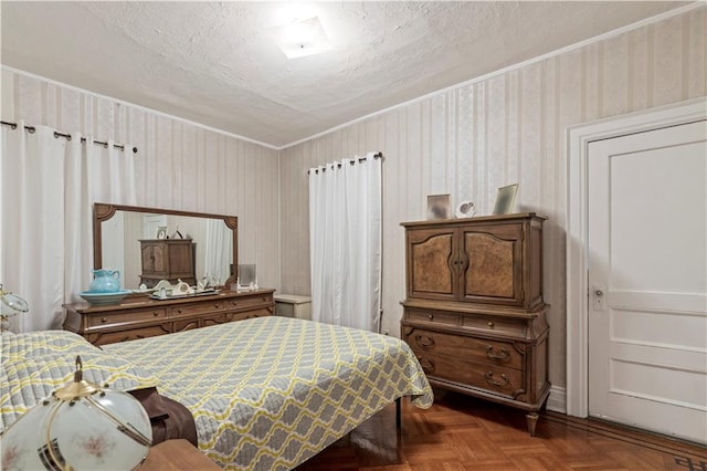 bedroom featuring ornamental molding, parquet floors, and a textured ceiling