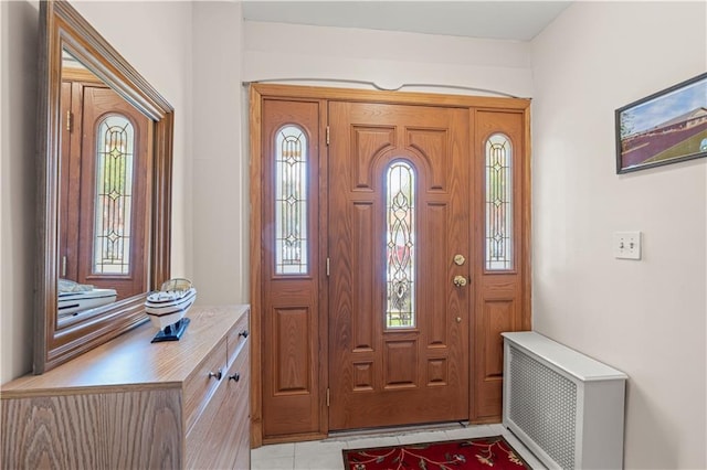 foyer with radiator and light tile patterned floors