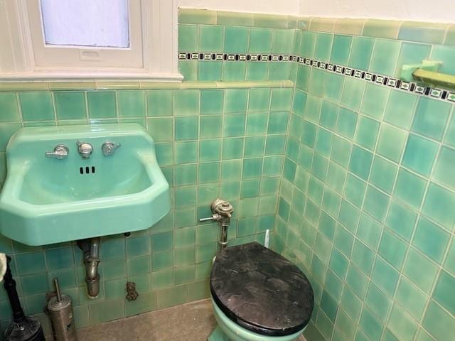 bathroom with tile walls and a sink