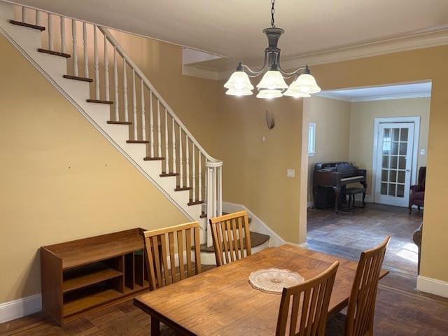 dining room featuring ornamental molding, baseboards, an inviting chandelier, and stairs