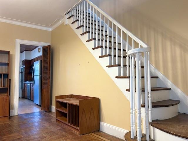 staircase featuring crown molding and baseboards