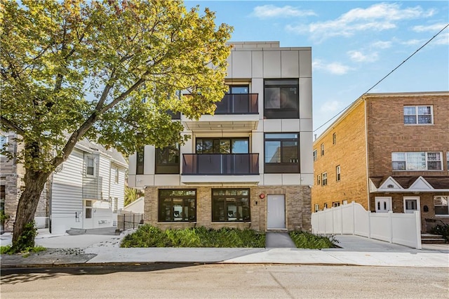 view of front facade featuring fence, brick siding, and stucco siding