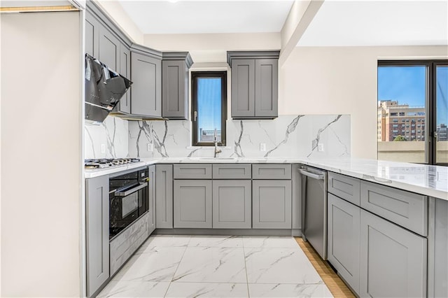 kitchen with gray cabinets, gas cooktop, oven, and stainless steel dishwasher