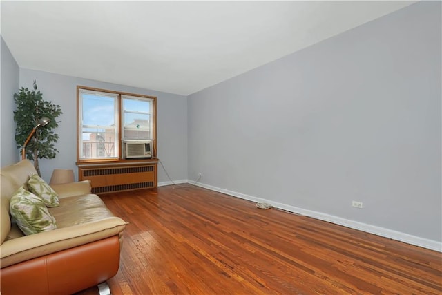 unfurnished room with cooling unit, radiator, and wood-type flooring