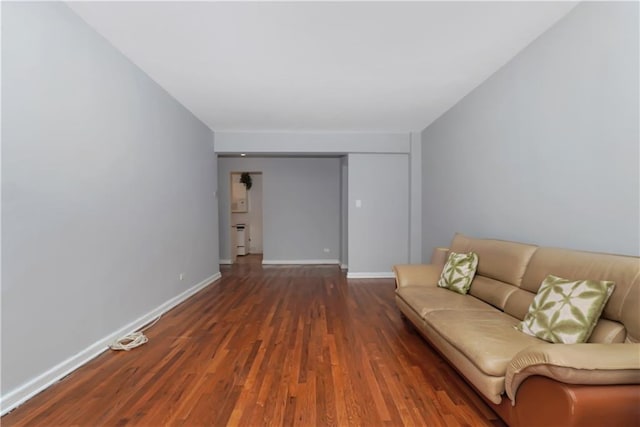 unfurnished living room featuring baseboards and wood finished floors