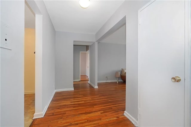 hallway with hardwood / wood-style flooring