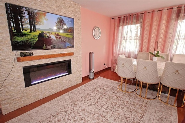 dining room featuring a large fireplace and wood finished floors