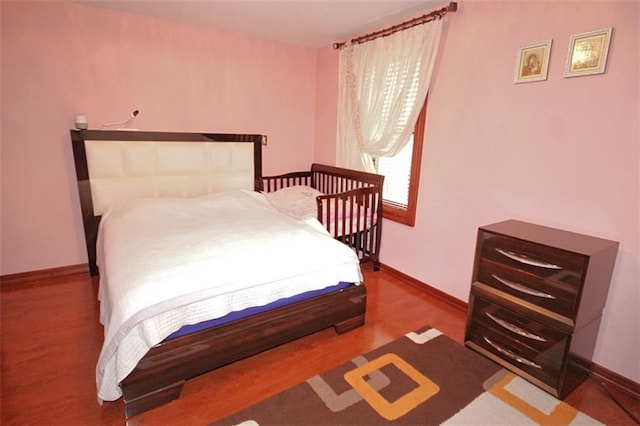 bedroom with wood finished floors and baseboards