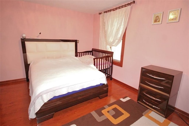 bedroom with baseboards and wood finished floors