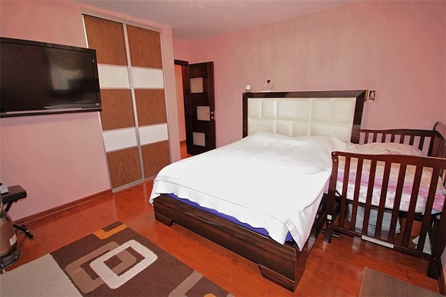 bedroom with baseboards and wood finished floors