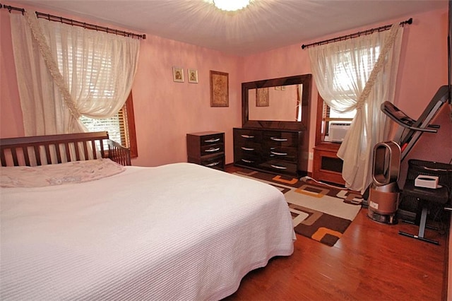 bedroom with wood finished floors and cooling unit