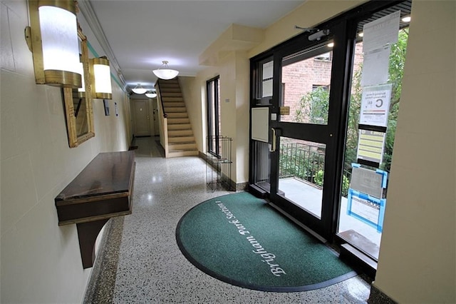 doorway to outside featuring speckled floor and stairs