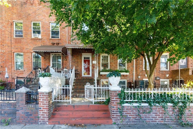 view of property with a fenced front yard and brick siding