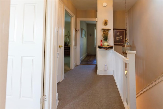 corridor featuring an upstairs landing and carpet flooring