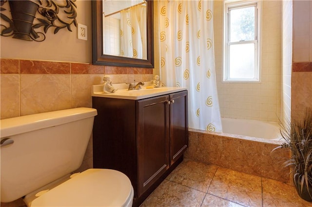 full bath featuring tile patterned flooring, tile walls, toilet, tiled shower / bath combo, and vanity