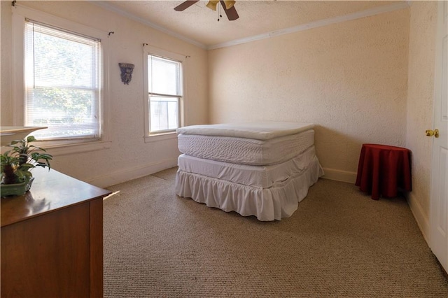 bedroom with a ceiling fan, crown molding, a textured wall, and baseboards