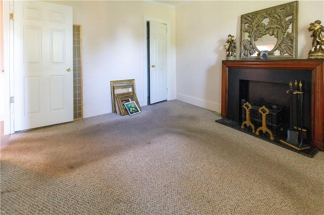 unfurnished living room with a fireplace with flush hearth, carpet, baseboards, and ornamental molding