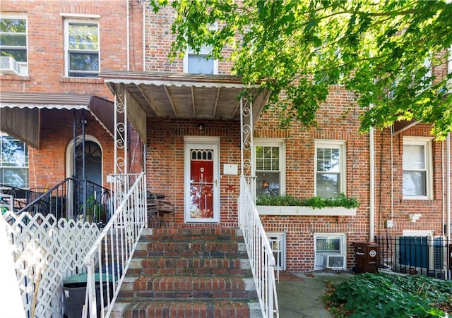 property entrance featuring fence and brick siding