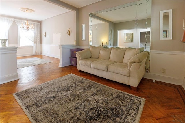 living room with baseboards and a notable chandelier