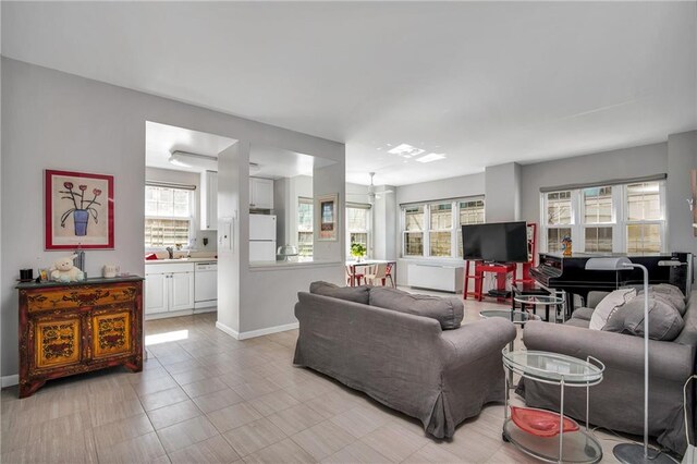 tiled living room featuring plenty of natural light and sink