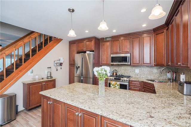 kitchen with decorative backsplash, sink, pendant lighting, and appliances with stainless steel finishes