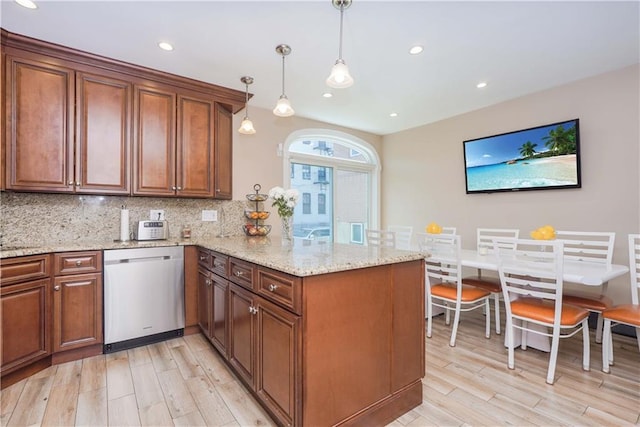 kitchen with kitchen peninsula, hanging light fixtures, stainless steel dishwasher, and light hardwood / wood-style flooring