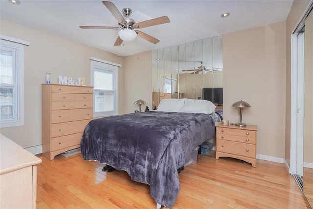 bedroom with multiple windows, light wood-type flooring, and ceiling fan