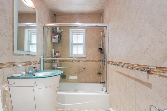 bathroom with tiled shower / bath, vanity, and tile walls