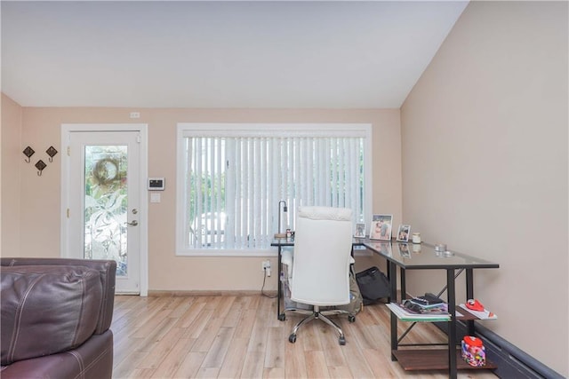 office featuring a healthy amount of sunlight, lofted ceiling, and light hardwood / wood-style flooring