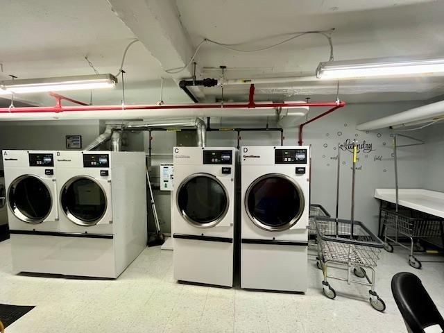 2270 Plumb 1st St Unit 4F, Brooklyn, NY 11229 - shared laundry area featuring washing machine and dryer, a garage, and tile patterned floors