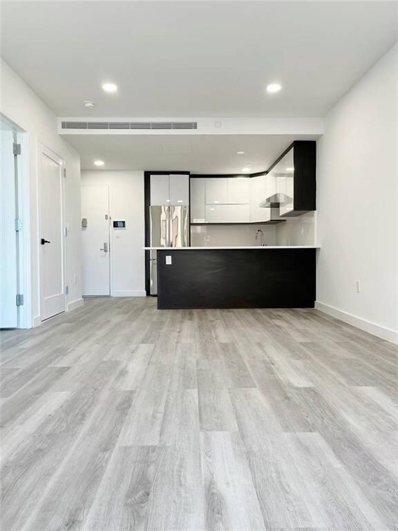 unfurnished living room with light hardwood / wood-style flooring