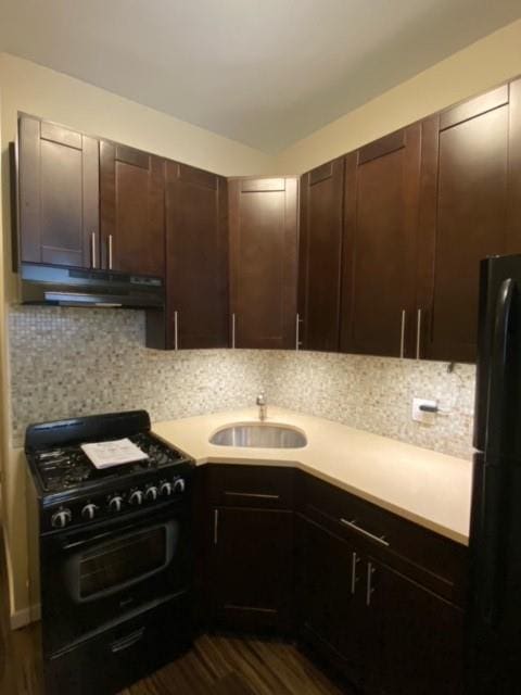 kitchen featuring sink, tasteful backsplash, dark brown cabinets, and black gas stove