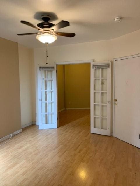 spare room with light hardwood / wood-style floors, french doors, and ceiling fan