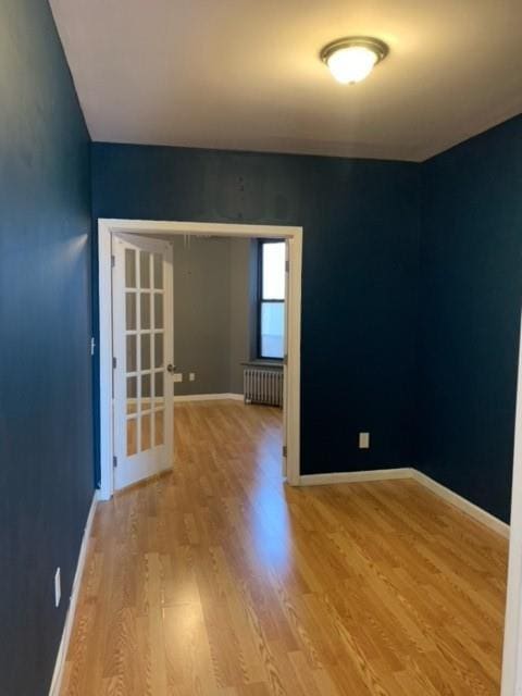 empty room featuring light wood-type flooring and radiator