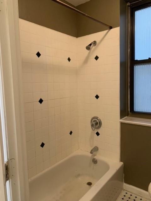 bathroom featuring tiled shower / bath combo and tile patterned floors