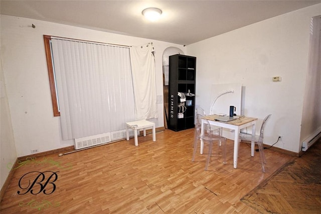 office area featuring a baseboard heating unit and hardwood / wood-style floors