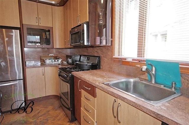 226 W End Ave, New York, NY 11235 - kitchen with a sink, light brown cabinetry, glass insert cabinets, and stainless steel appliances
