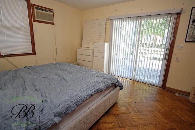 bedroom with parquet flooring, access to exterior, and an AC wall unit