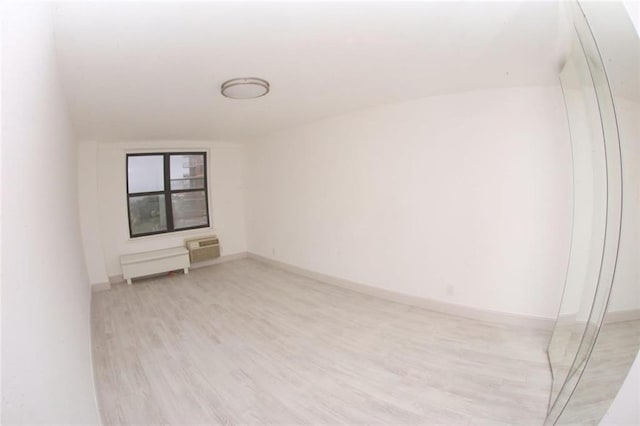 spare room with light hardwood / wood-style floors and a wall mounted air conditioner