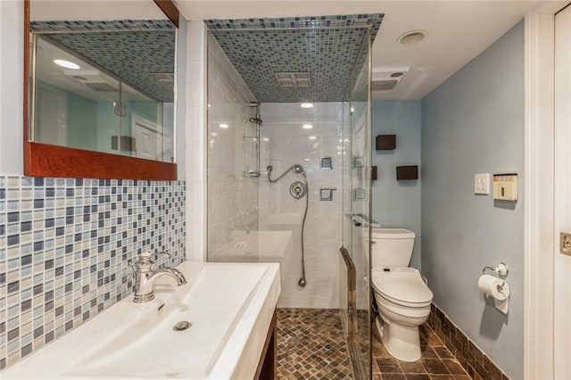 bathroom featuring decorative backsplash, toilet, an enclosed shower, and sink